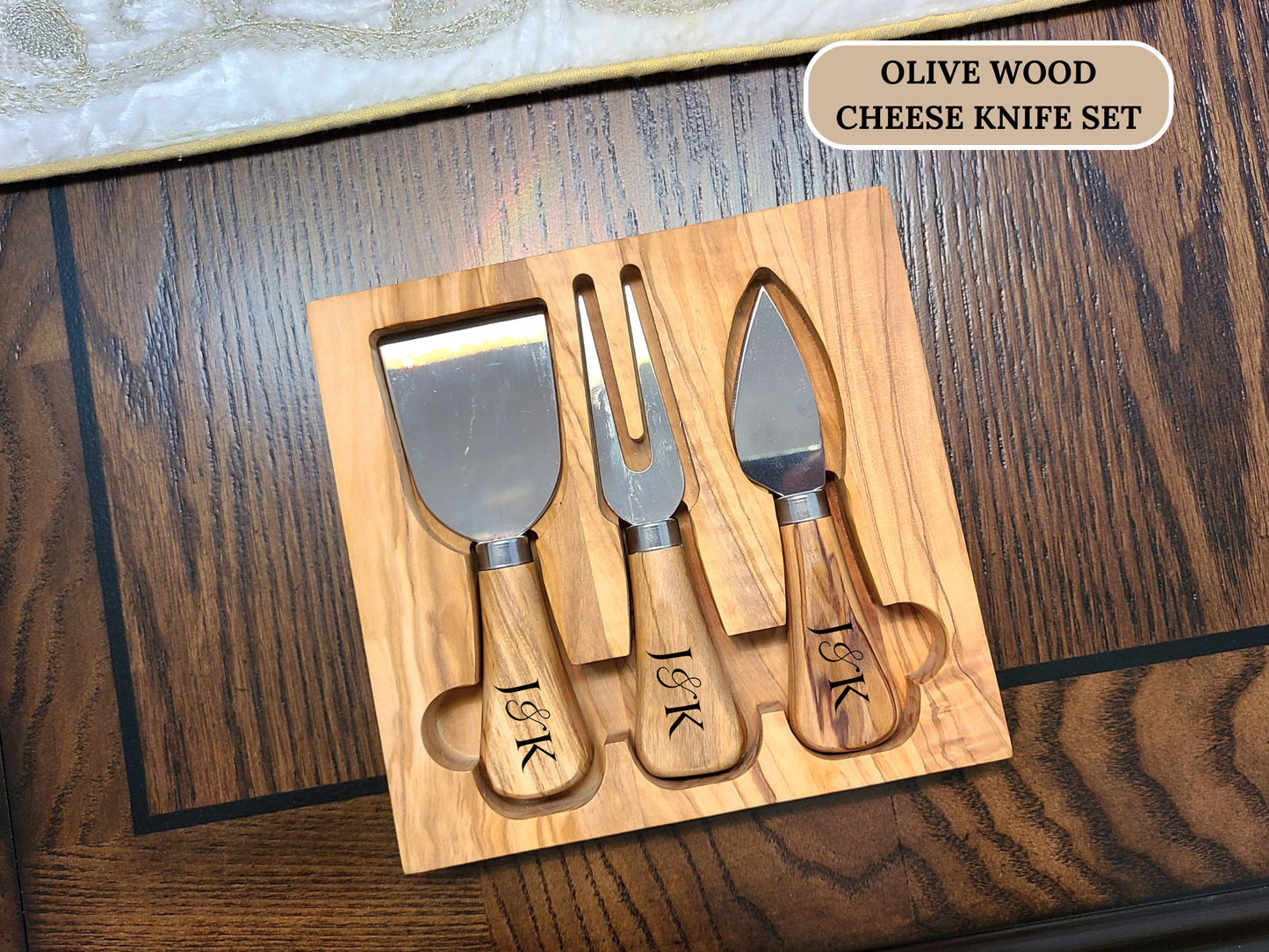 Olive wood cheese knife set with personalized initials on a wooden surface